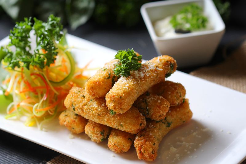 Golden crispy mozzarella sticks with marinara sauce